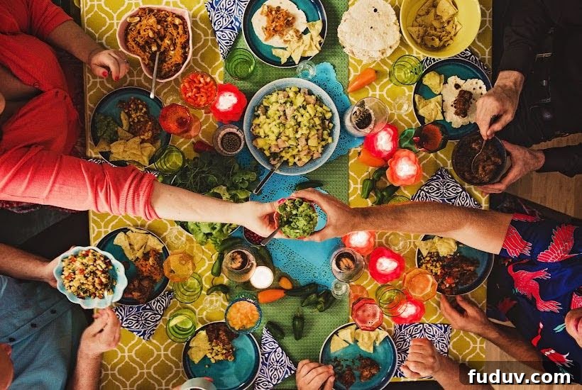 Taco Party Menu Ideas for a Crowd: Recipes, Sides & Drinks 4 Top view of people eating taco party foods at a table.