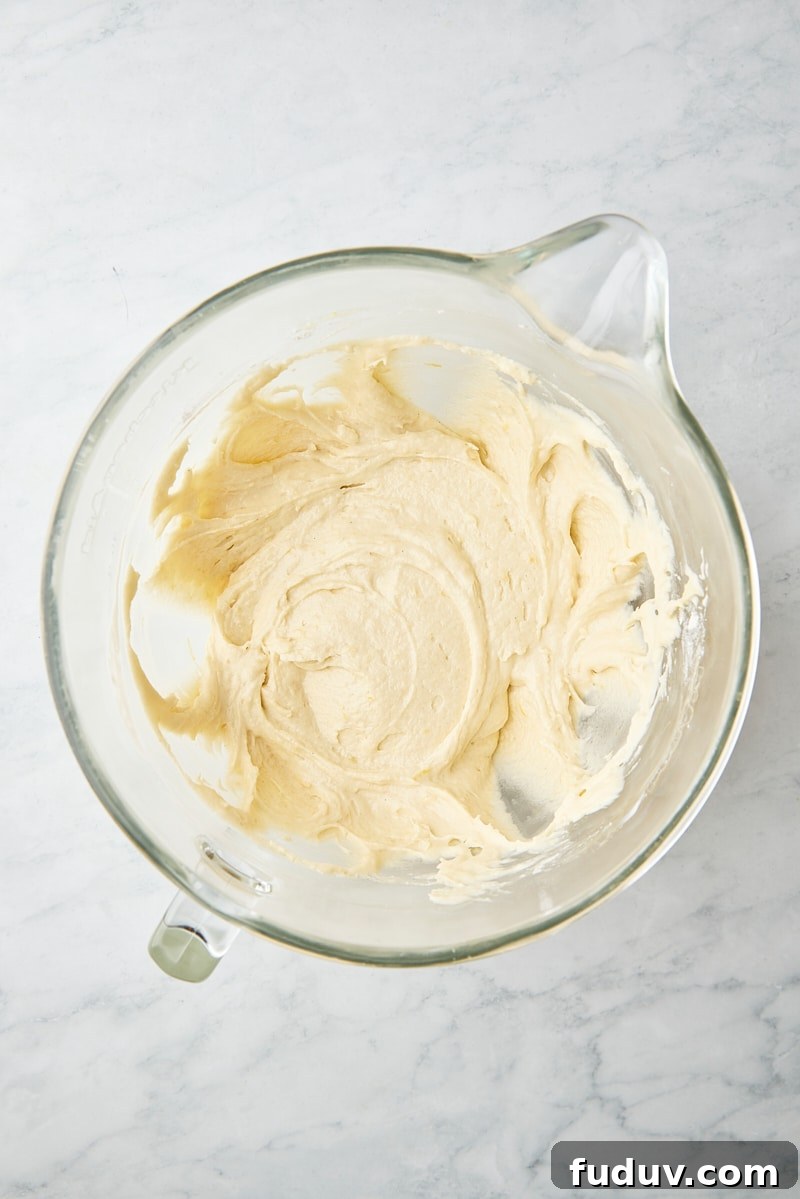 Mixed cake batter in glass mixer bowl