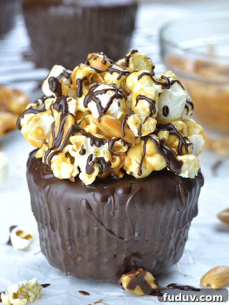 Chocolate cupcakes garnished with salted caramel, peanuts and popcorn .
