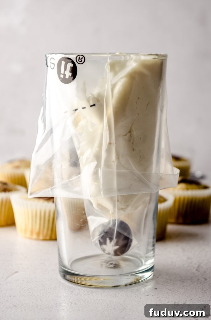 Piping bag in glass with white frosting on one side