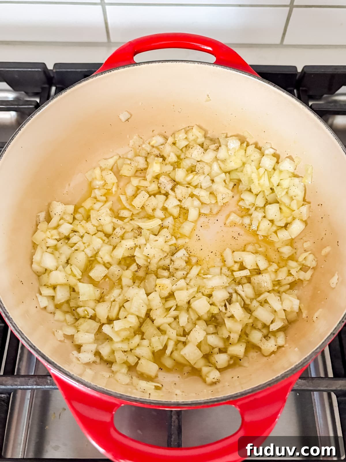 Onions frying in oil in a dutch oven.