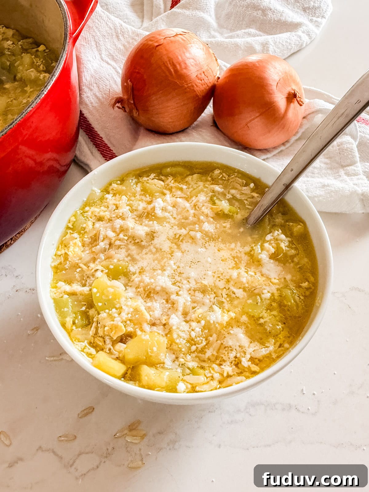 A bowl of zucchini soup with a spoon in it.