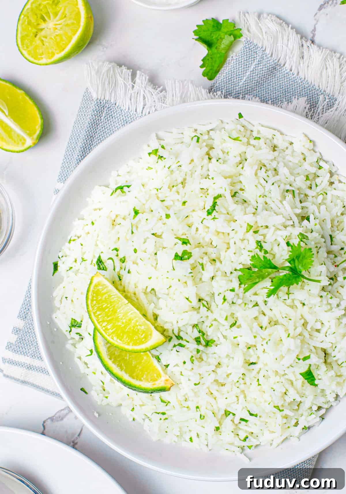 Cilantro Lime Rice Recipe: Flavorful Side Dish in 20 Minutes 6 Overhead of lime rice in white bowl with lime wedges and cilantro
