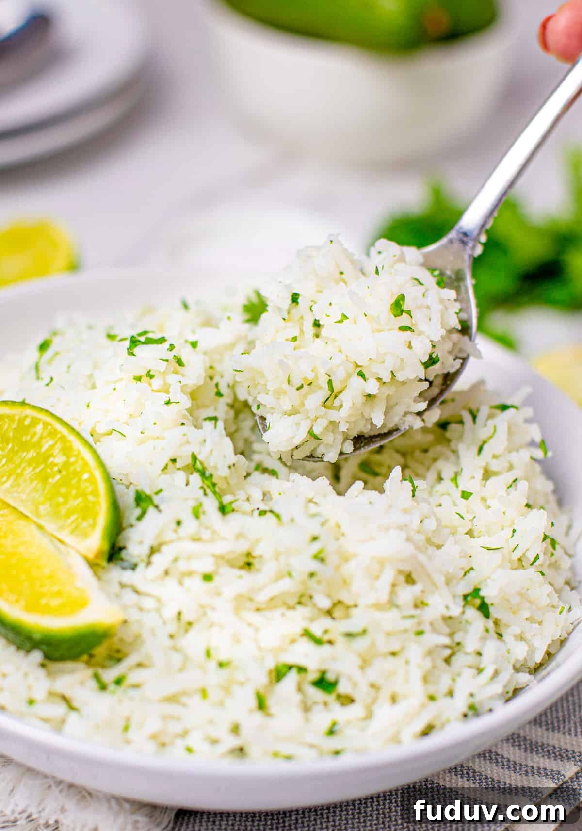 Cilantro Lime Rice Recipe: Flavorful Side Dish in 20 Minutes 7 Serving spoon scooping up some lime rice out of white bowl