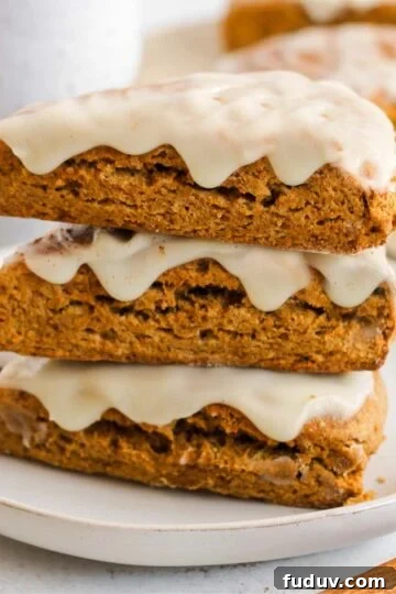 Pumpkin scones stacked on a plate.