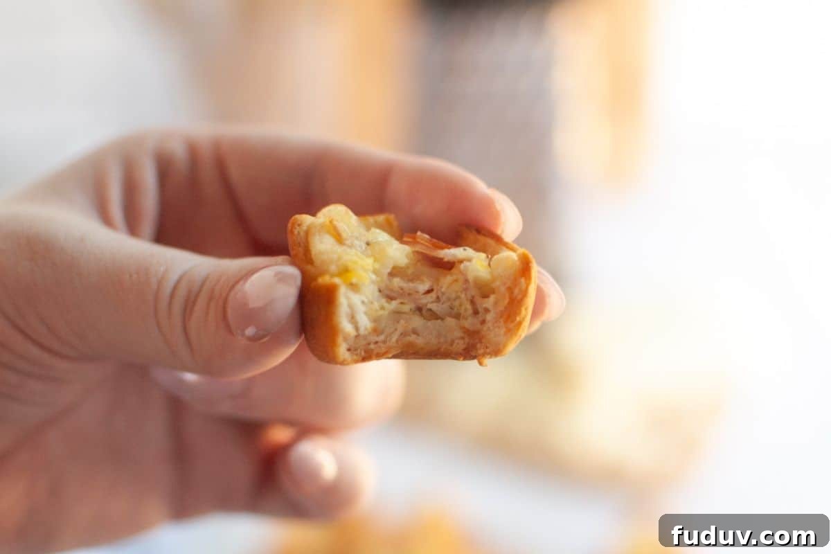 A hand holds a partially eaten Ham and Cheese puff, revealing layers of pastry, ham, and cheese.