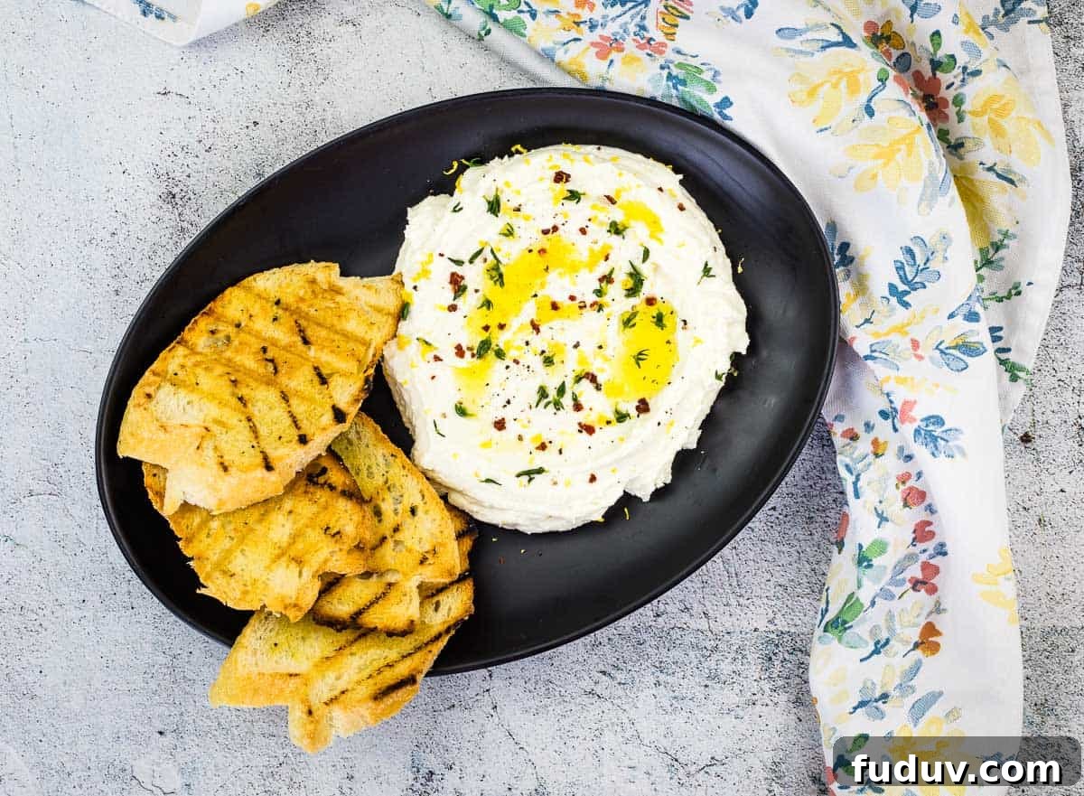 Whipped Feta on a black plate with grilled bread.