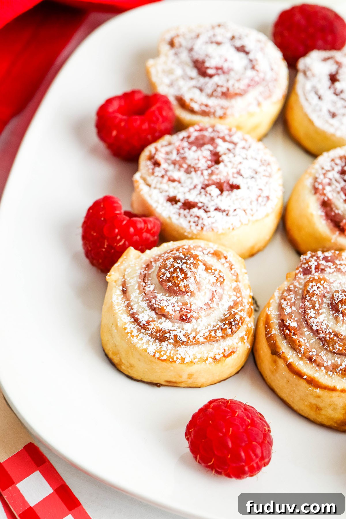 Raspberry Pastries dusted with powdered sugar on white plate.