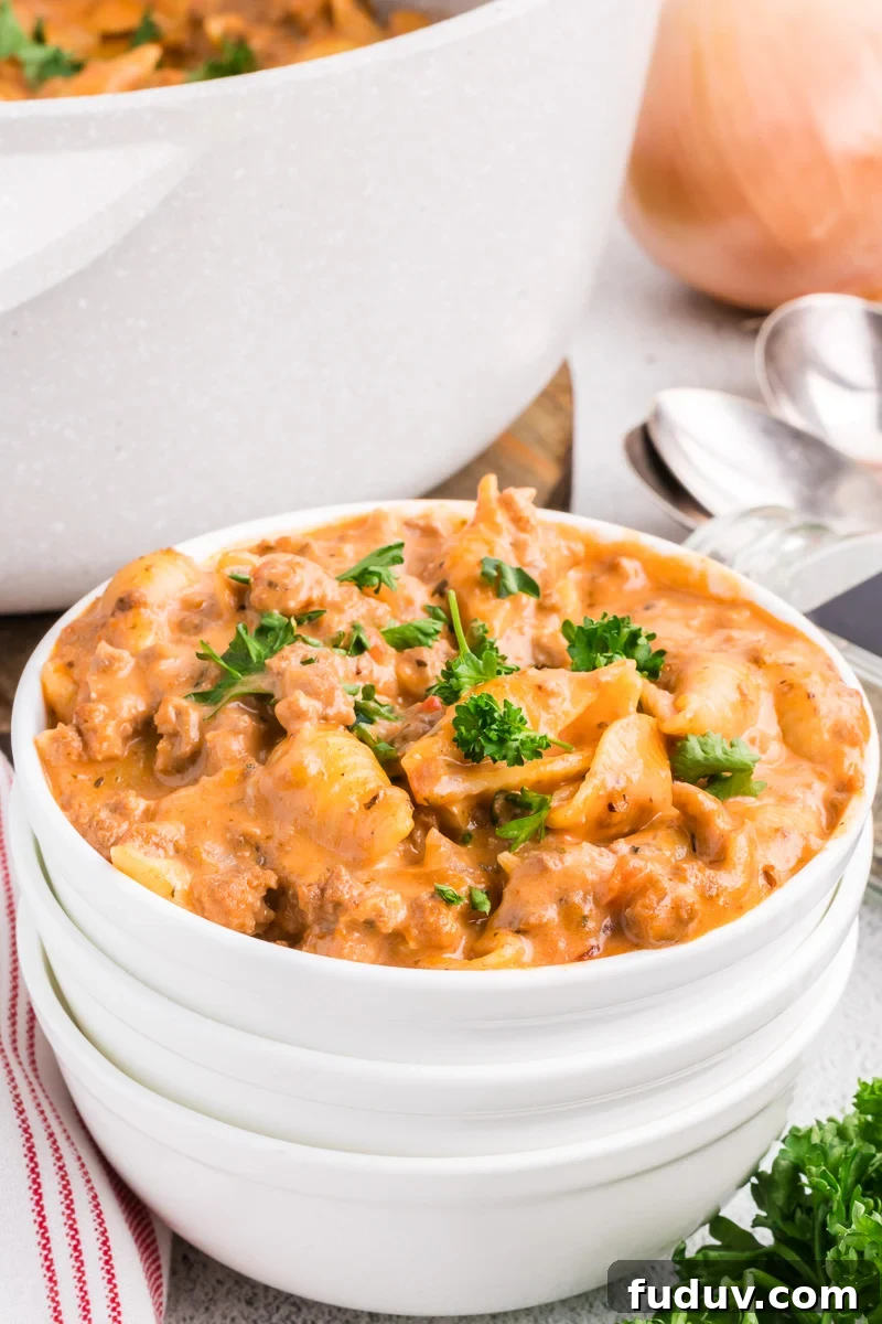 Creamy beef pasta in a white bowl.