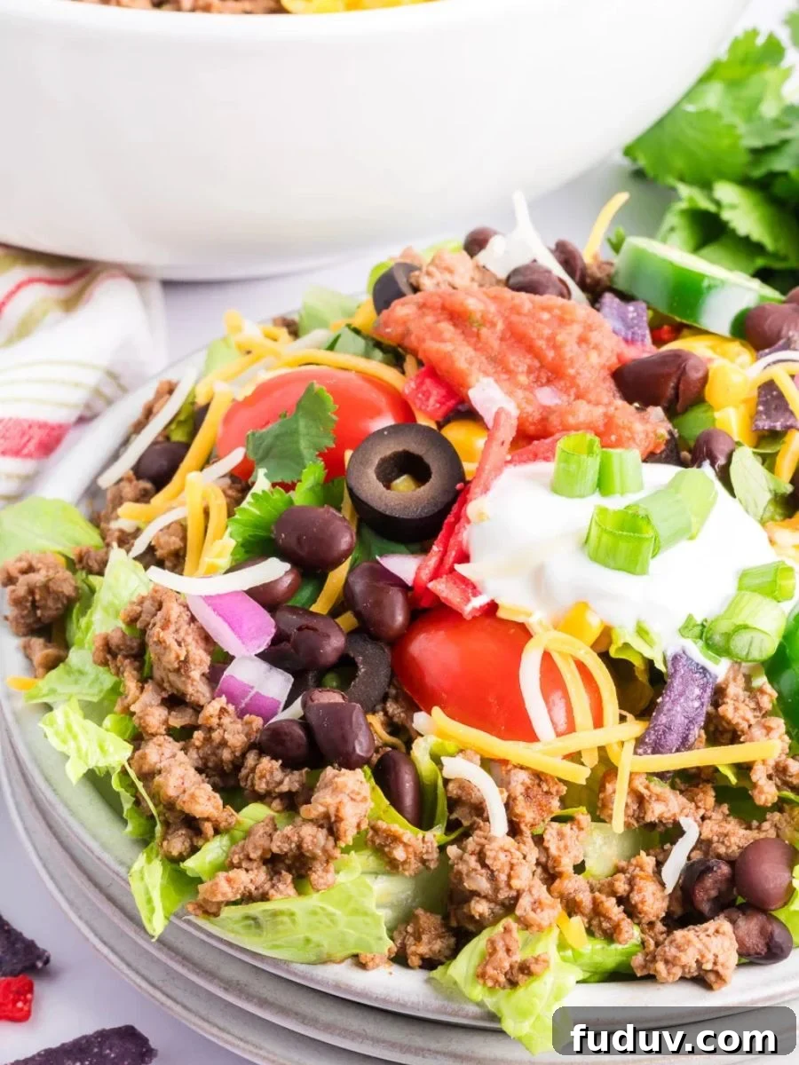 Taco salad with ground beef in a white bowl.
