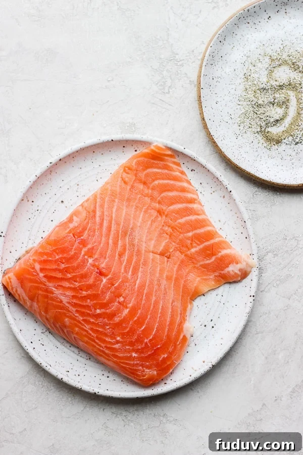 A plate with a piece of raw salmon. 