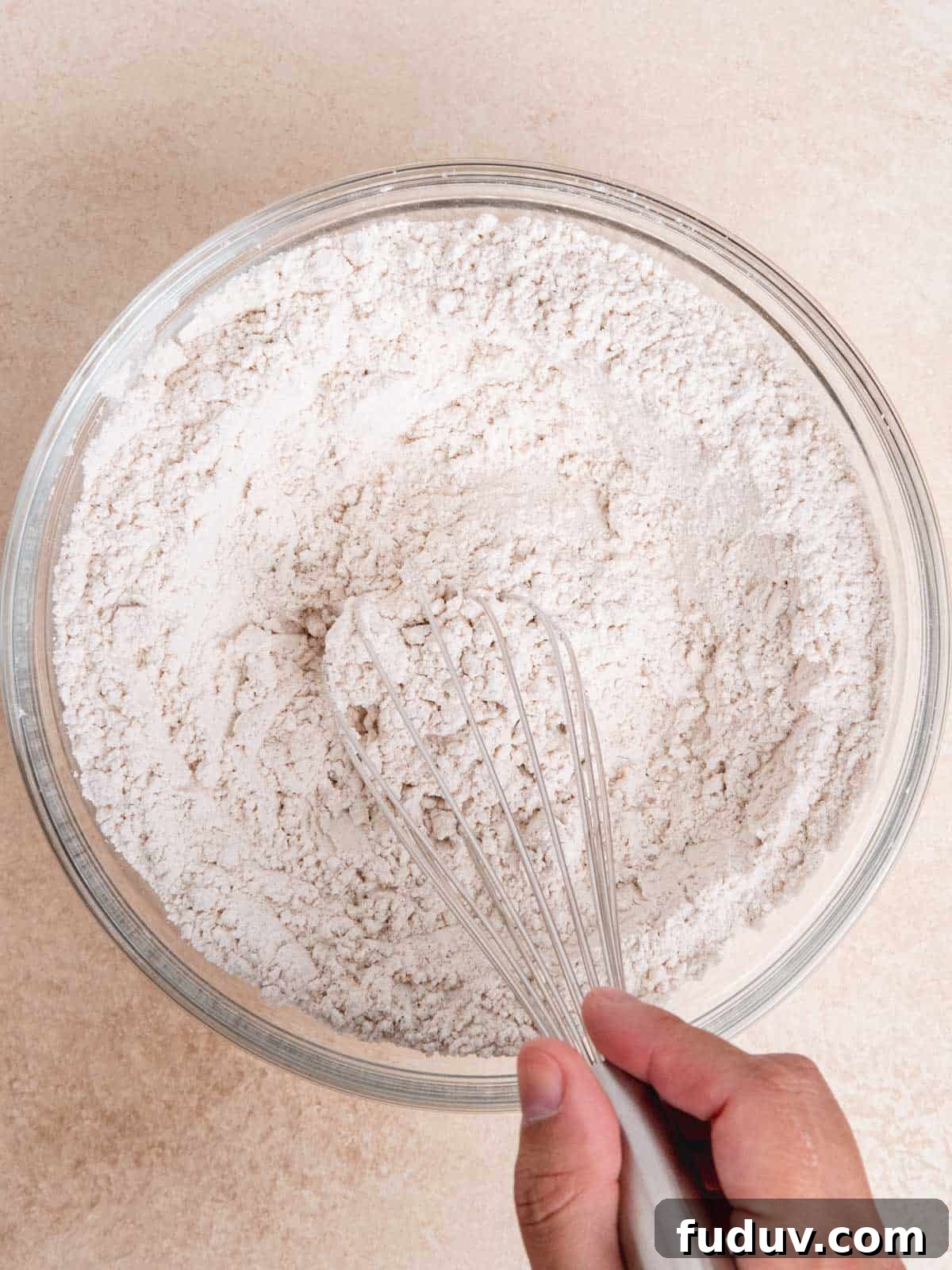 Whisking flour, baking soda, salt, and chai spice in a bowl.