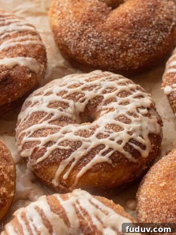Glazed apple cider donuts on baking tray.