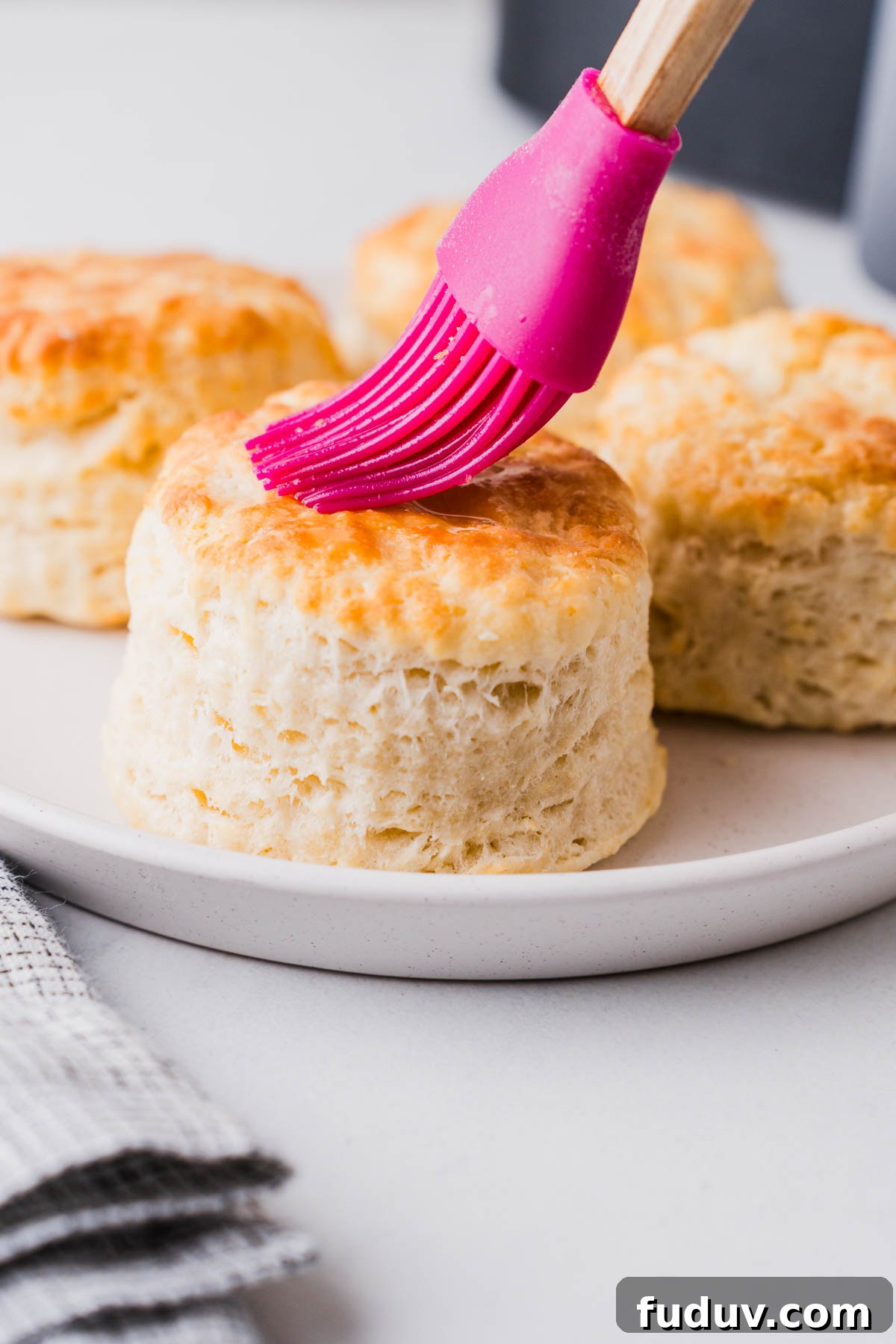 Crispy Air Fryer Biscuits: Quick Flaky Homemade Recipe 13 brushing oil on the air fryer biscuit with a brush.