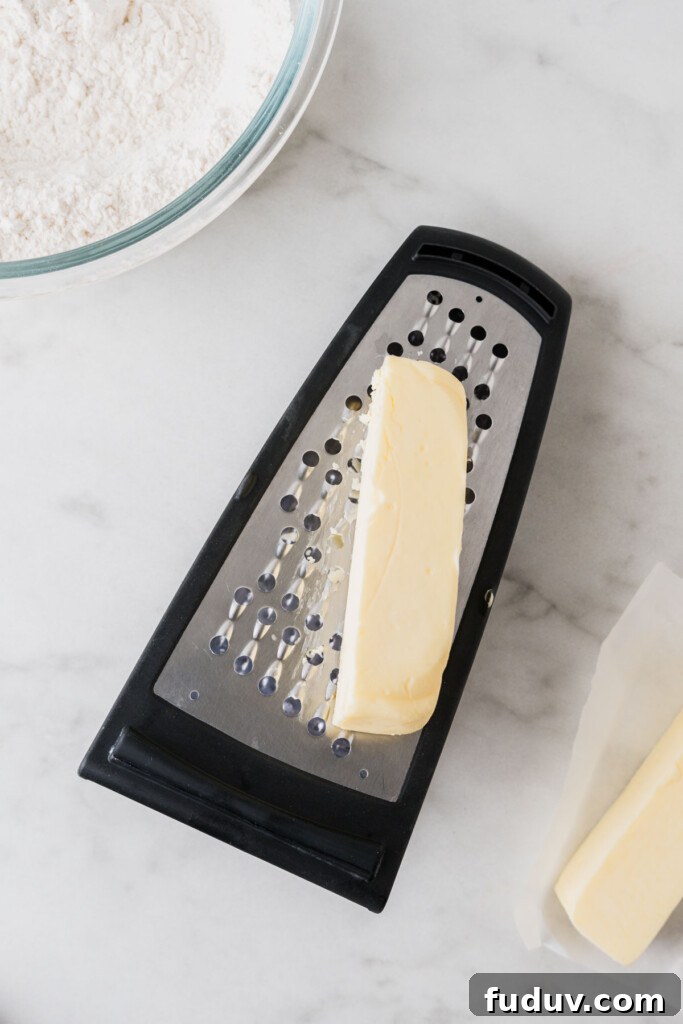 Crispy Air Fryer Biscuits: Quick Flaky Homemade Recipe 5 cold butter on grater on a white background.