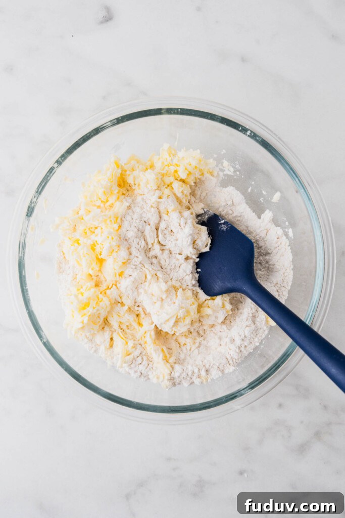 Crispy Air Fryer Biscuits: Quick Flaky Homemade Recipe 6 grated butter and flour in a bowl with a blue mixing spoon.