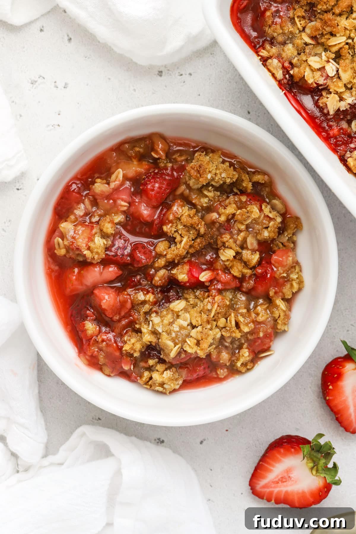 a bowl of gluten free strawberry rhubarb crisp with oat topping