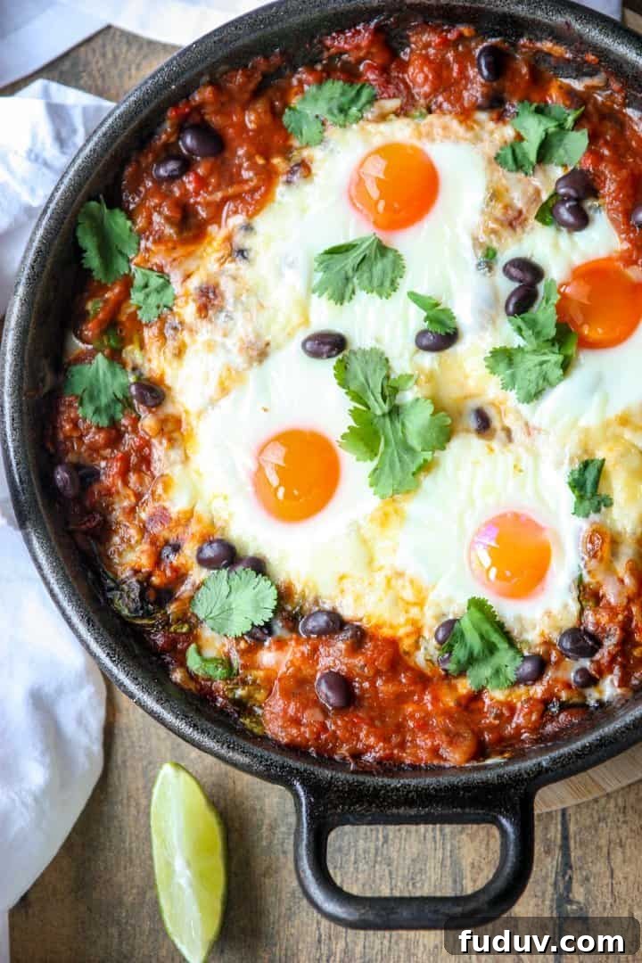 Baked Huevos Rancheros Recipe: Flavorful Rancher’s Eggs Casserole 2 Top shot of a black skillet filled with baked huevos rancheros.