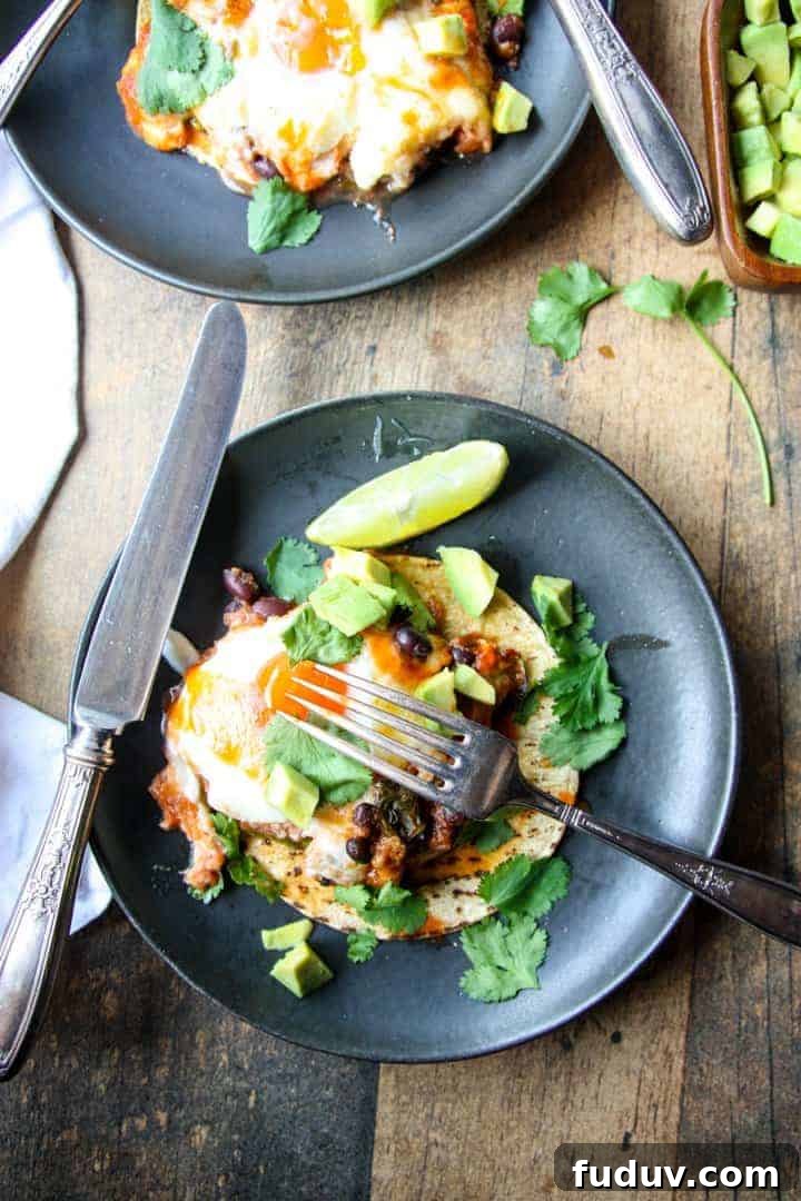 Baked Huevos Rancheros Recipe: Flavorful Rancher’s Eggs Casserole 3 A plate of huevos rancheros on a table, with a knife and fork.