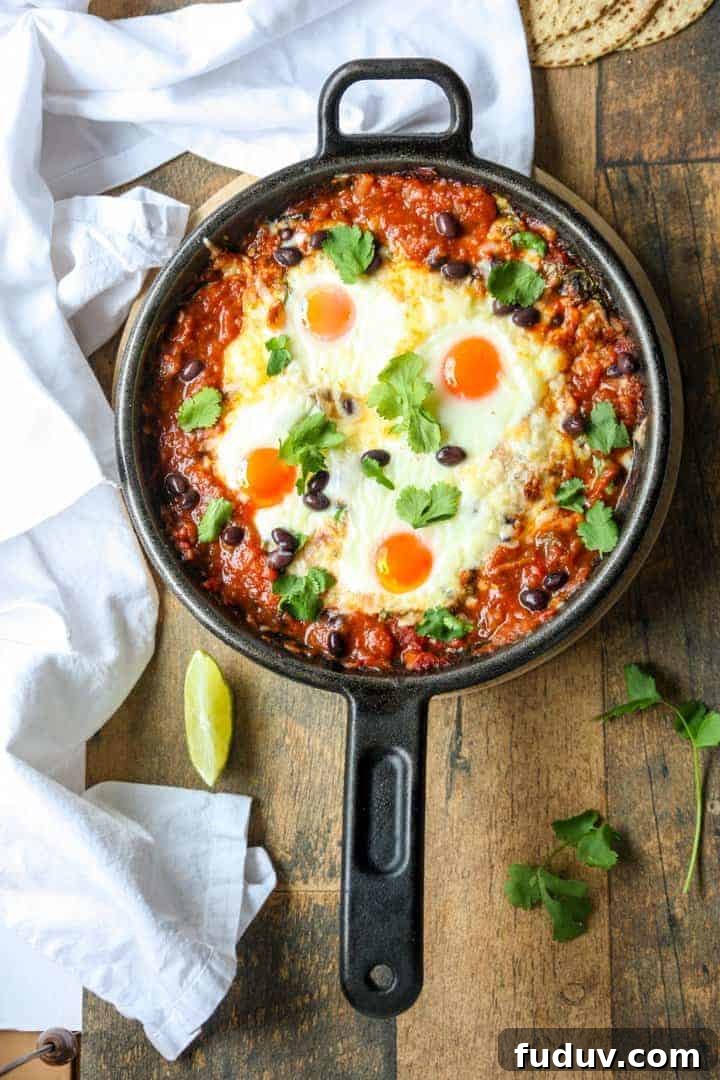 Baked Huevos Rancheros Recipe: Flavorful Rancher’s Eggs Casserole 5 Top shot of a black skillet filled with baked huevos rancheros.