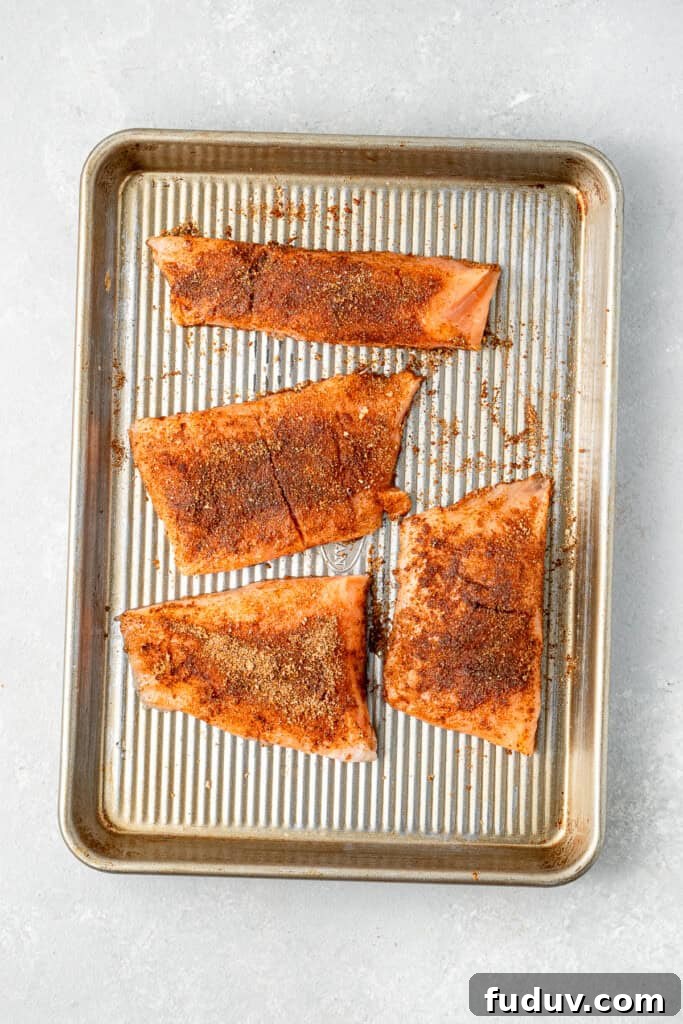 Grilled Salmon Tacos with Creamy Avocado Lime Crema 5 The salmon fillets coated in the spice mixture on a baking tray.