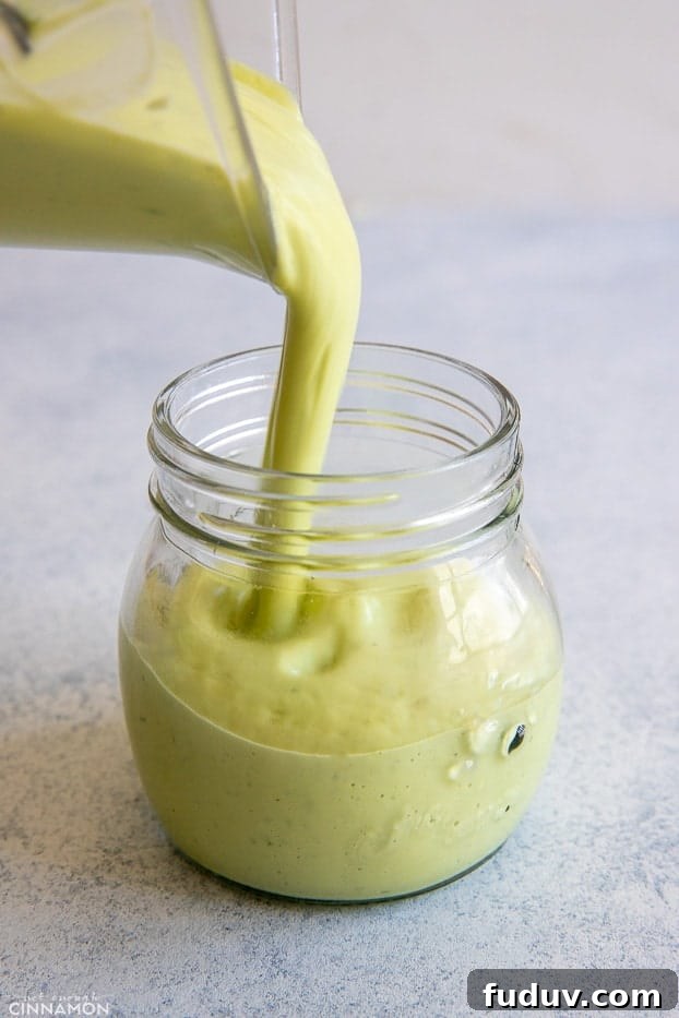 avocado ranch creamy avocado ranch dressing being poured into a small mason jar