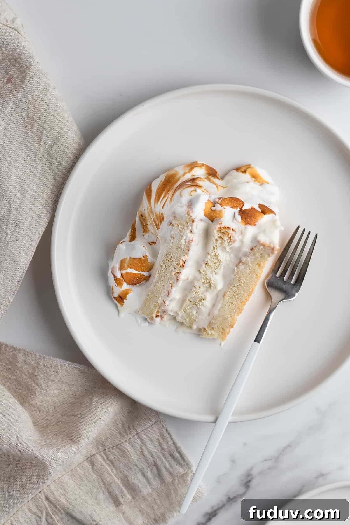 A slice of vanilla meringue cake on a dessert plate