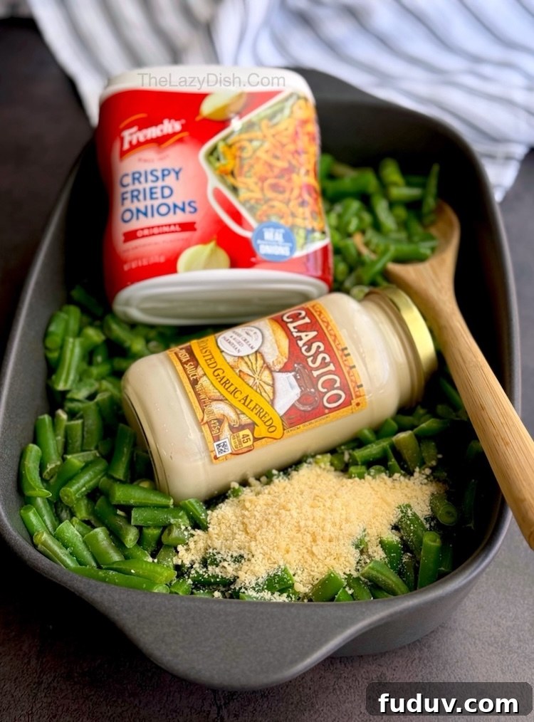 The best yummy green bean casserole veggie side dish made with a store-bought jar of Alfredo sauce, parmesan cheese, and frozen green beans.