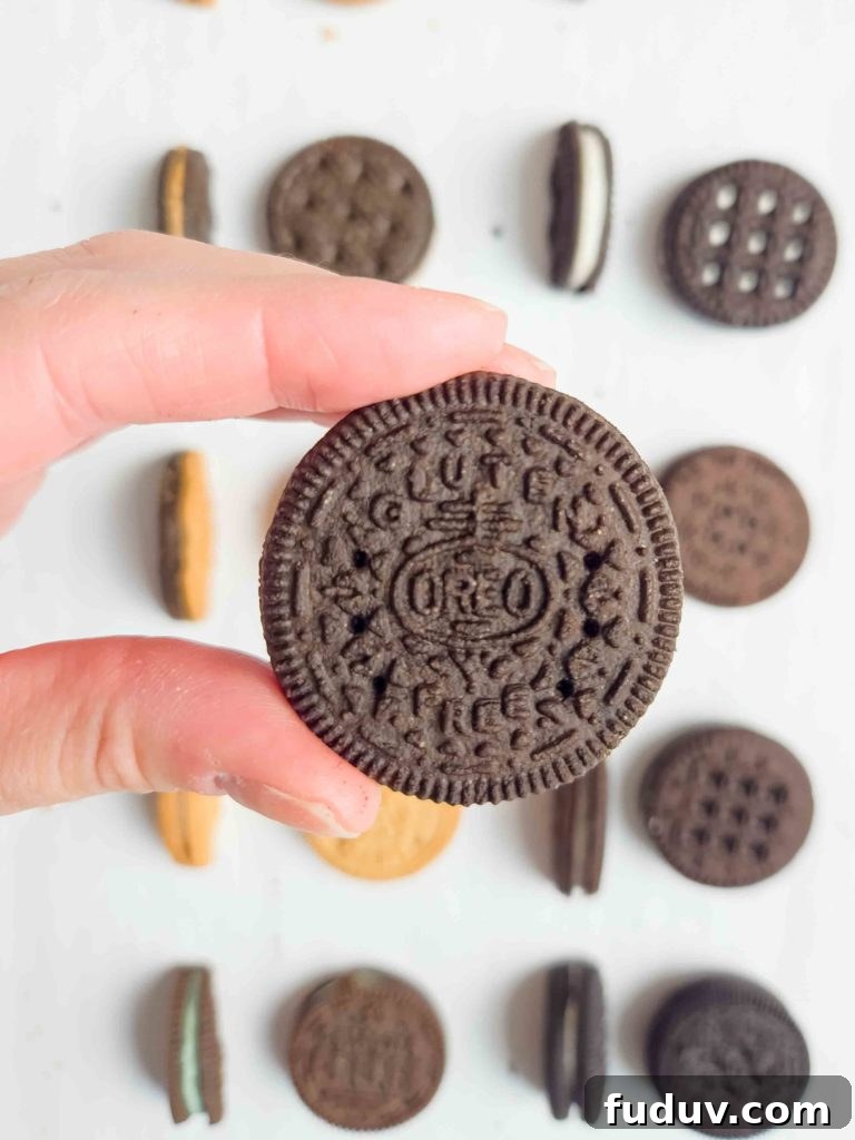 someone is holding out a gluten free Oreo cookie above all the other gluten free sandwich cookies.