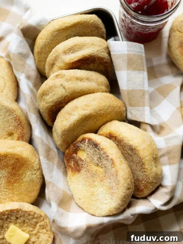 Whole Wheat English muffins arranged on a farmhouse kitchen towel in a bread pan