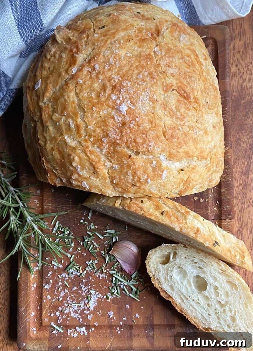 No-Knead Dutch Oven Bread Recipe for Crispy Crust and Soft Crumb 5 Bread on cutting board with herbs.