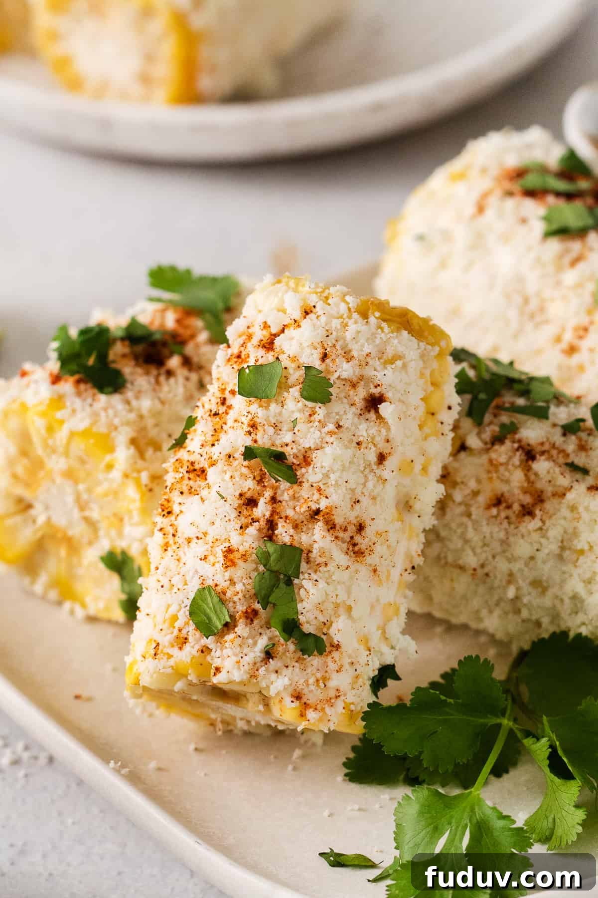 Elote corn on a plate topped with cilantro.