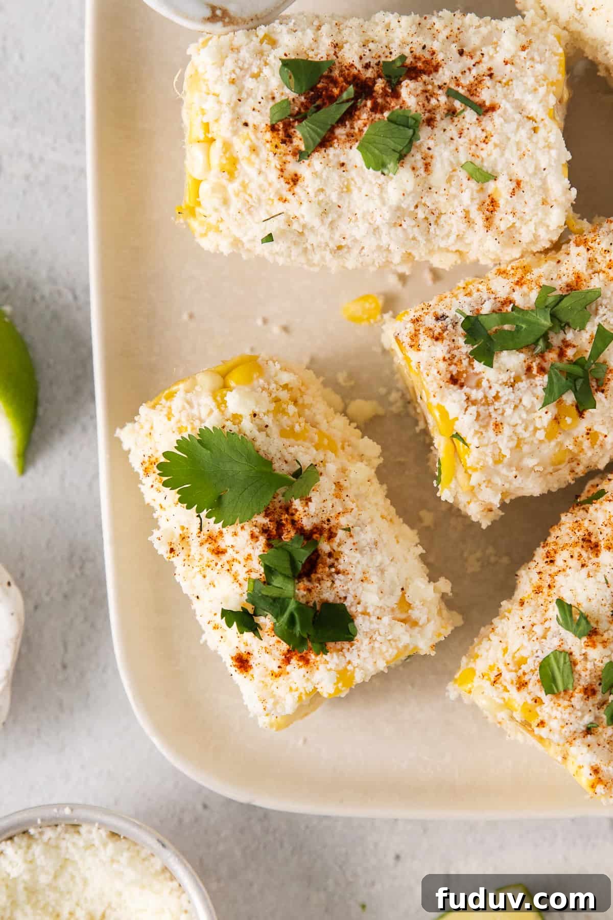 Elote corn on a plate topped with cilantro.