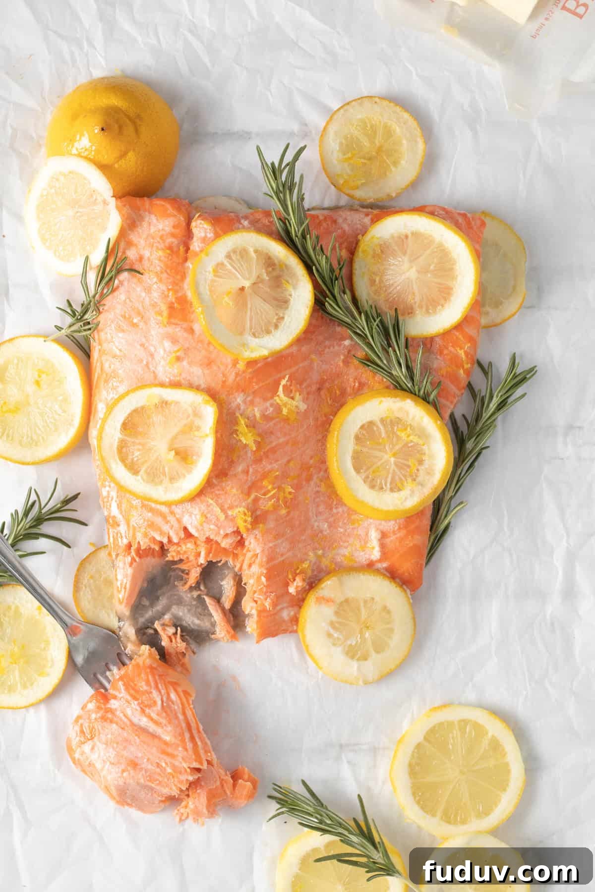 Baked lemon butter salmon with a fork taking a piece out.