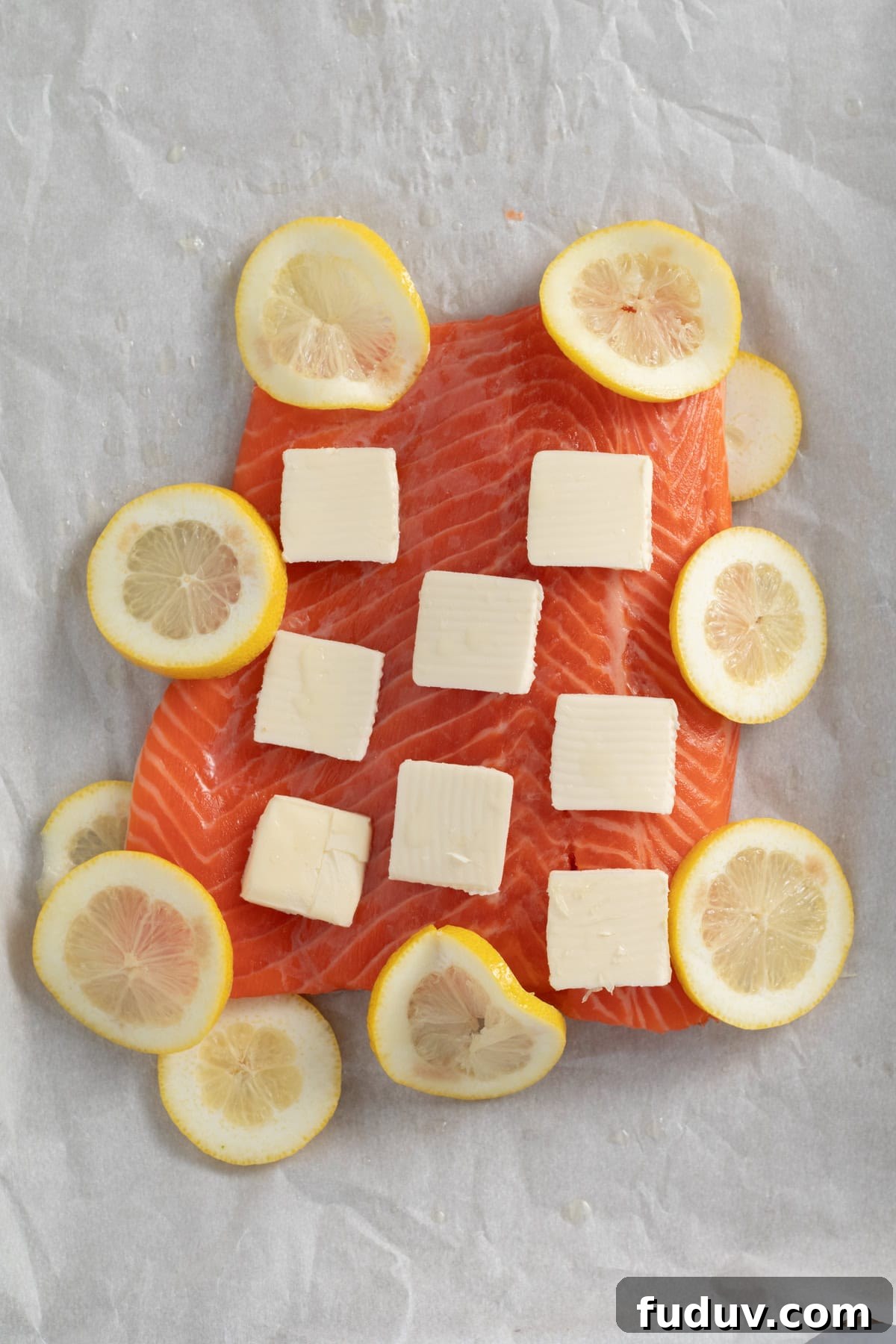 butter and lemons on raw salmon.