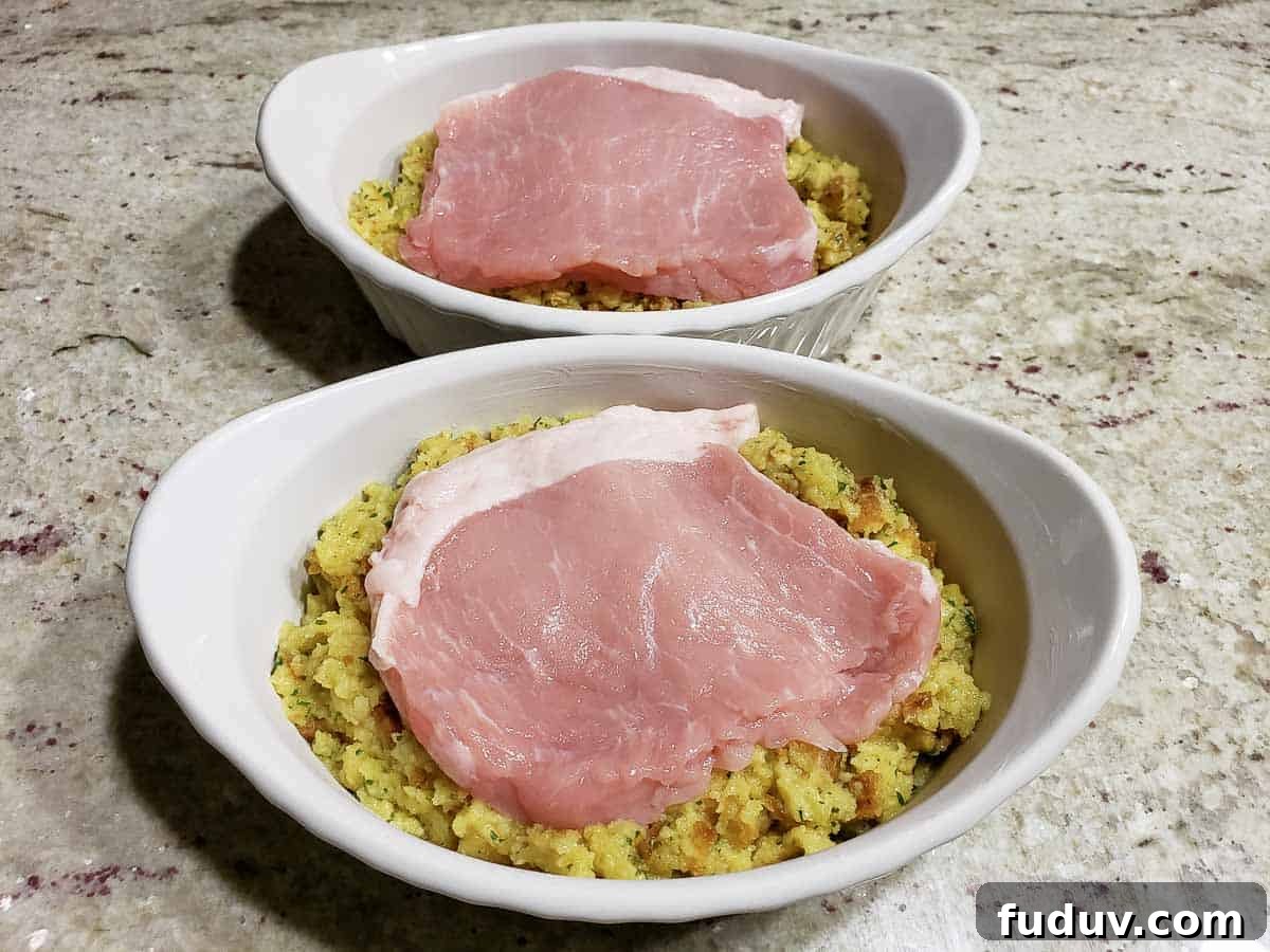 a pork chop layered over stuffing in two casserole baking dishes.