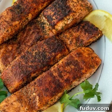 Four grilled salmon fillets on a serving platter