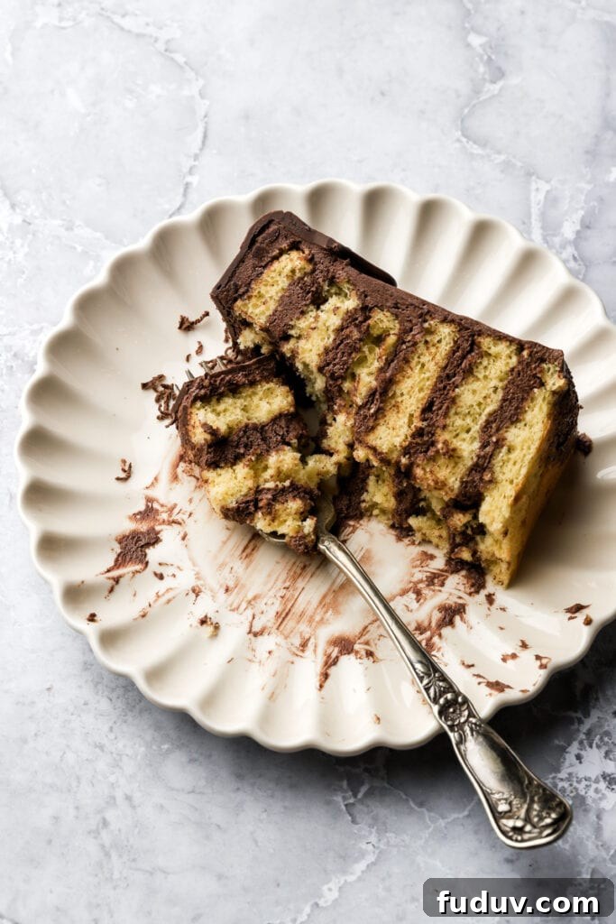 slice of cake on a plate with a few bites taken out and a fork
