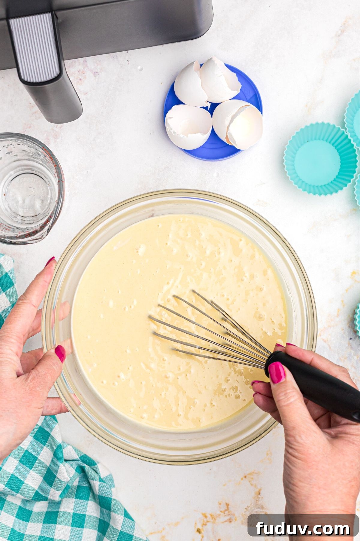 Cake mix being mixed in a clear glass bowl, making cake batter.