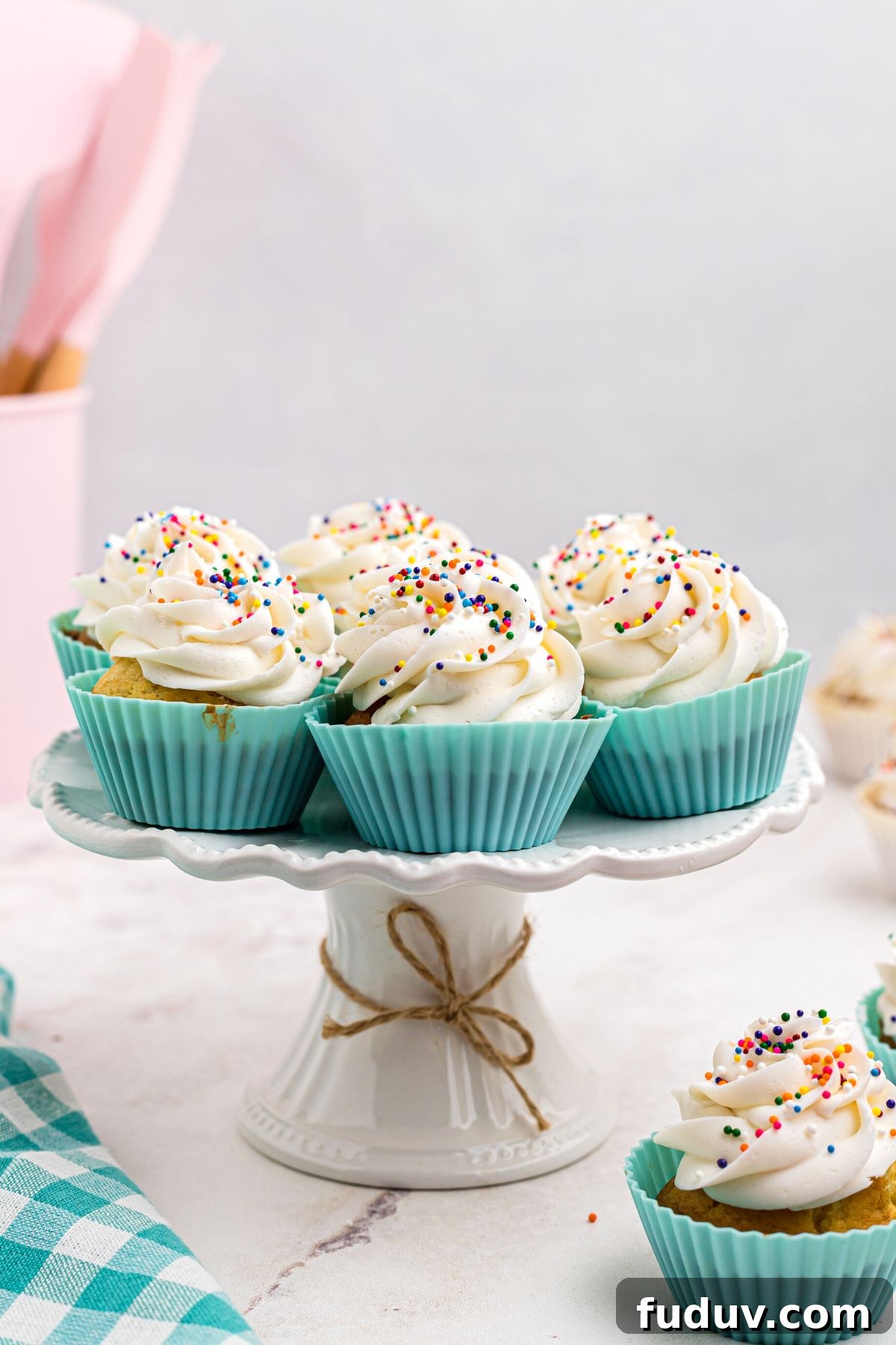 Air fried cupcakes in light blue liners on a white marble cake plate