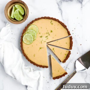 key lime pie tart with 3 slices cut.