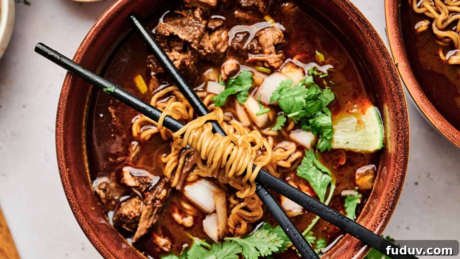 31 Cozy Cinnamon Recipes to Warm Your Home and Soul 16 A bowl of ramen with meat, cilantro, and a lime wedge, topped with noodles wrapped around chopsticks.