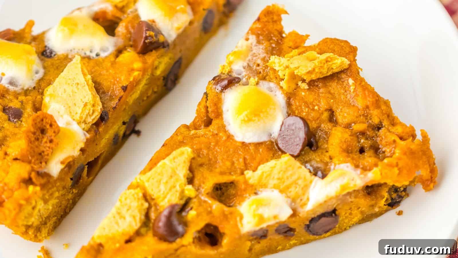 31 Cozy Cinnamon Recipes to Warm Your Home and Soul 28 Two slices of pumpkin s'mores pie on a white plate, topped with chocolate chips, graham crackers, and toasted marshmallows.