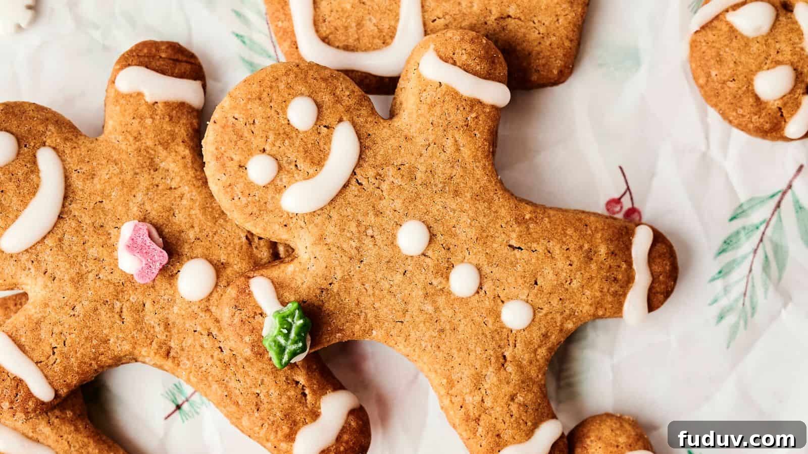 31 Cozy Cinnamon Recipes to Warm Your Home and Soul 30 Several gingerbread cookies shaped like people, decorated with white icing and small colorful candies, are perfectly arranged on a piece of parchment paper.