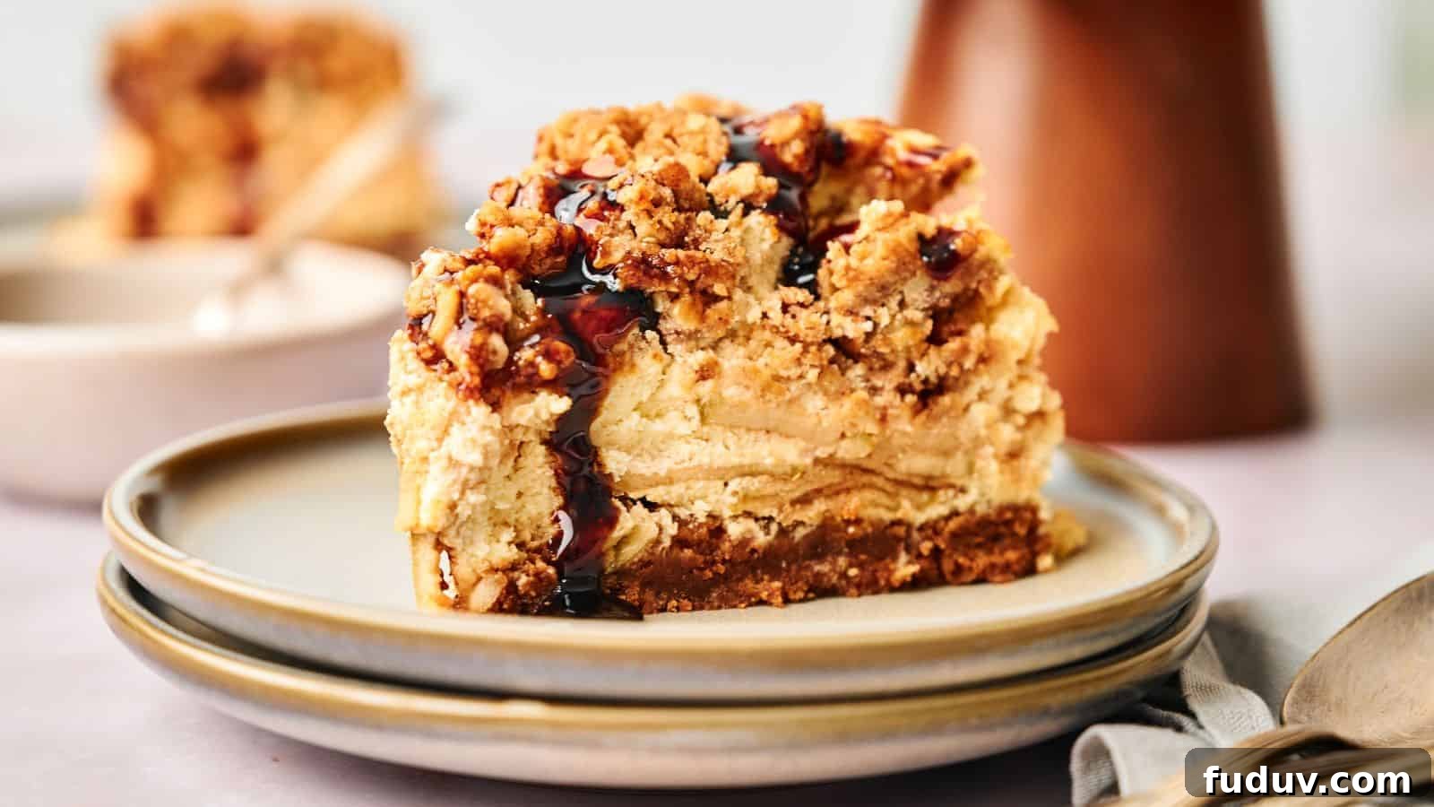 31 Cozy Cinnamon Recipes to Warm Your Home and Soul 32 A slice of apple pie stuffed cheesecake on a plate with a spoon.