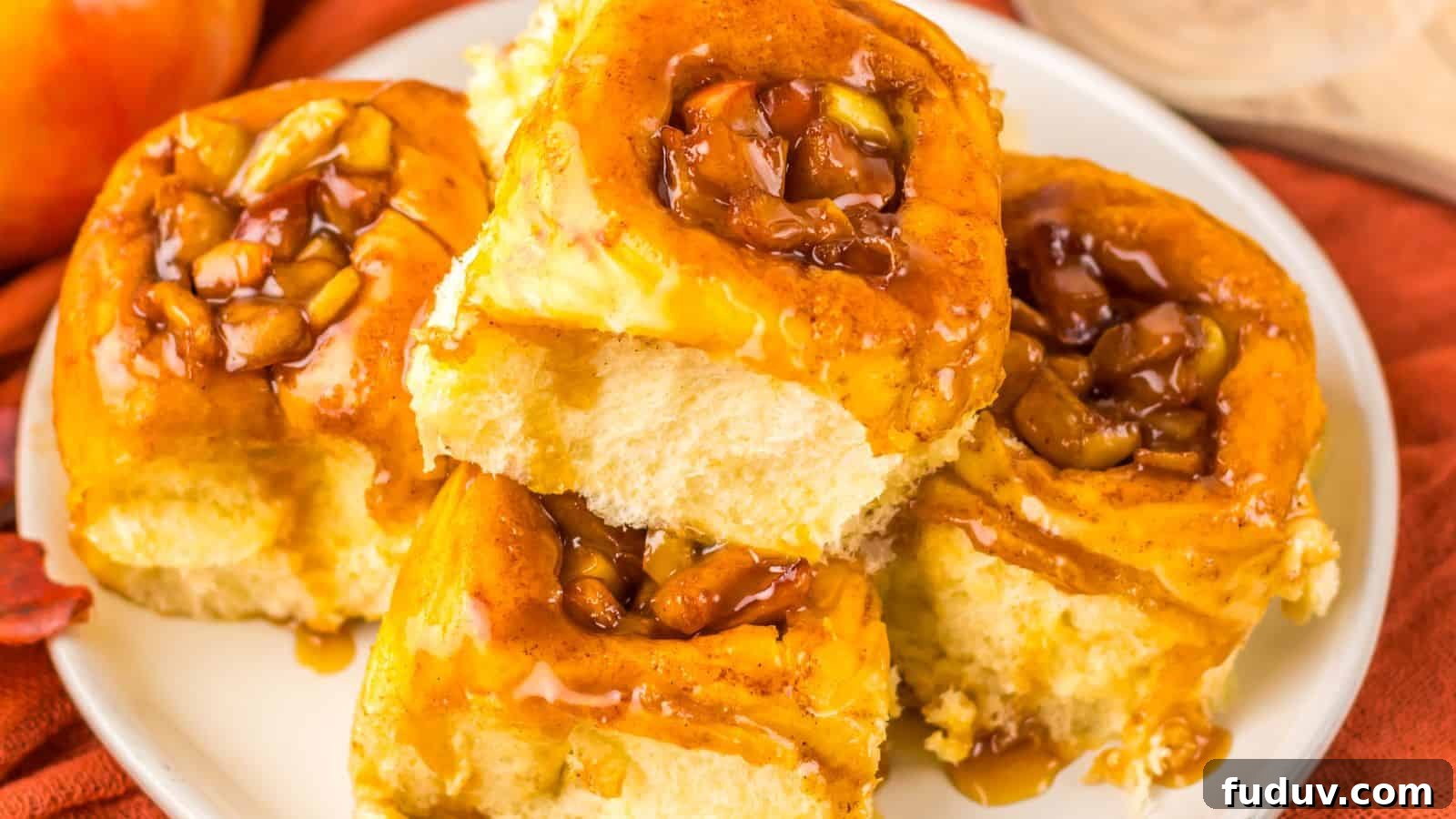 31 Cozy Cinnamon Recipes to Warm Your Home and Soul 6 A plate of five sticky buns topped with caramelized nuts and sauce, resting on a red cloth.