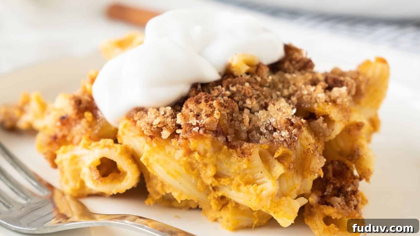 31 Cozy Cinnamon Recipes to Warm Your Home and Soul 8 A plate of baked pasta with a crispy, browned topping and dollops of white sauce.