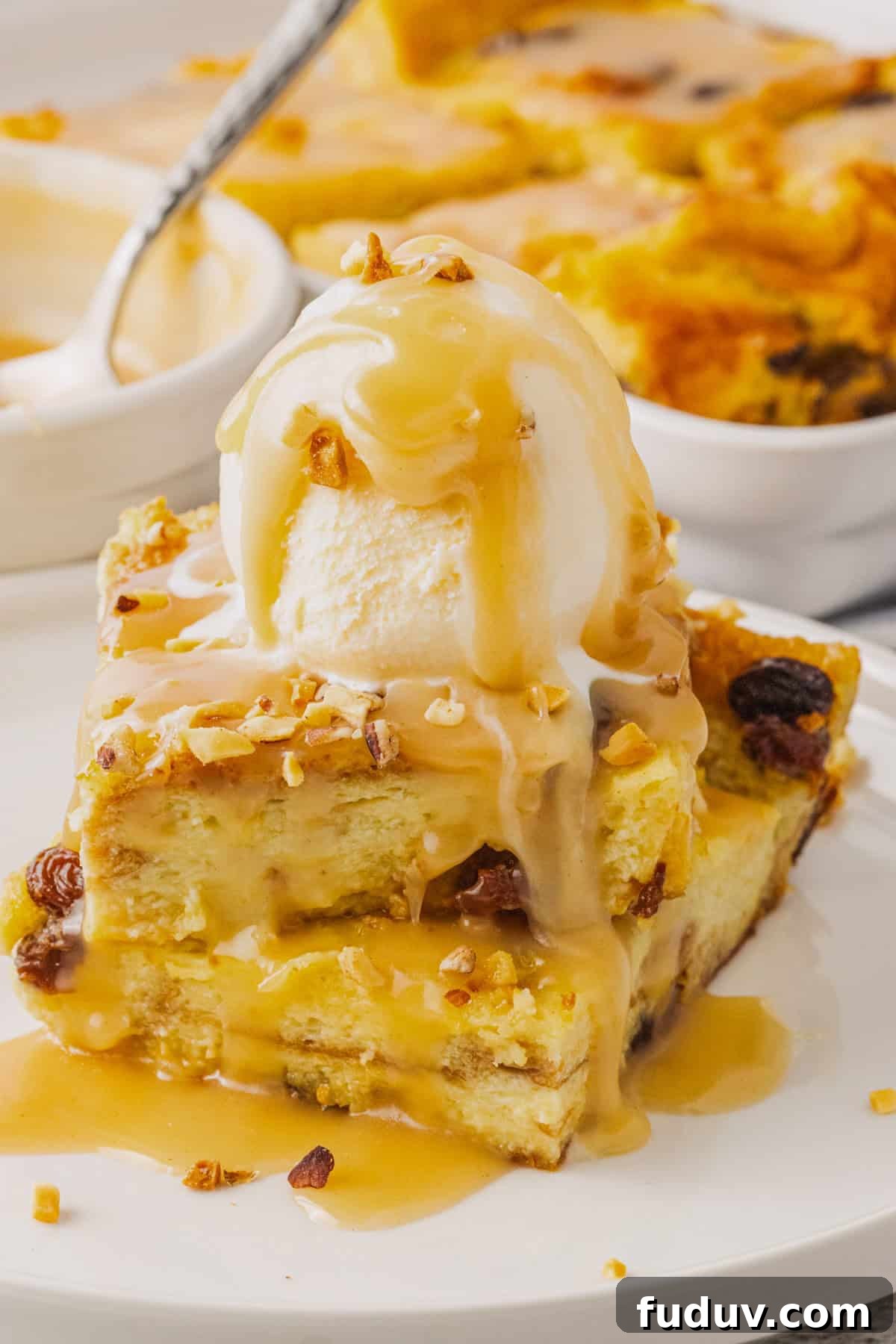 Decadent Bread Pudding with Warm Rum Sauce Recipe 12 The completed bread pudding with a scoop of vanilla ice cream and butter rum sauce poured over.