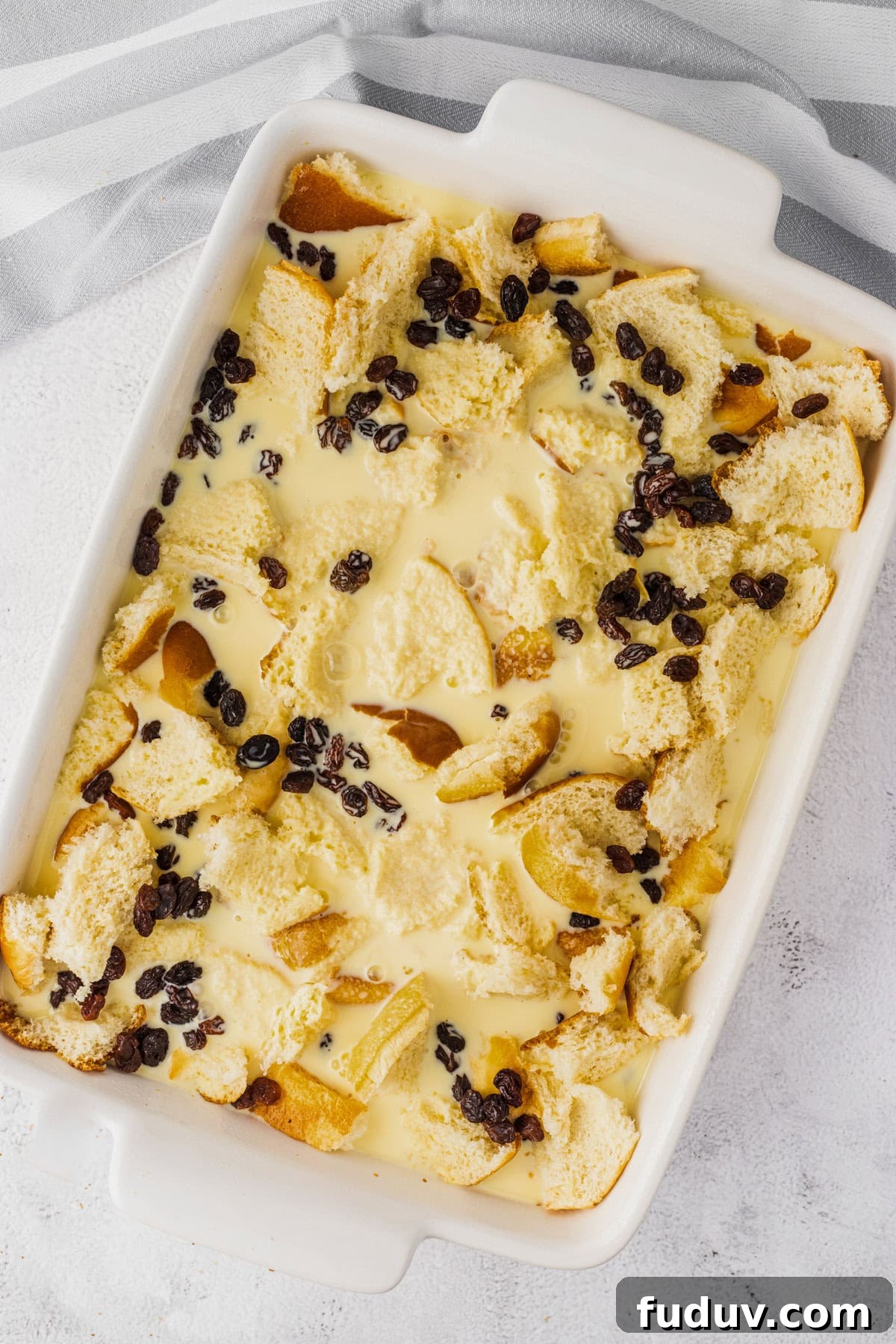 Decadent Bread Pudding with Warm Rum Sauce Recipe 8 Adding the custard layer to the casserole dish.