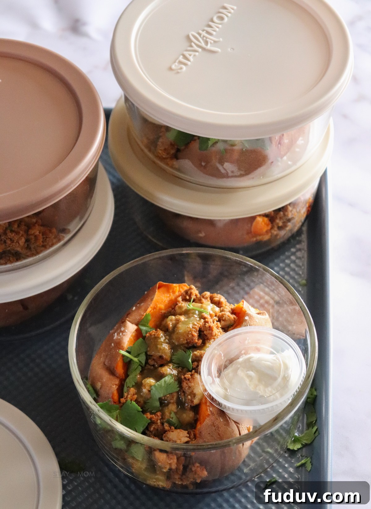 Baked sweet potato bowls showing meal prep bowl with sweet potato topped with ground turkey and green salsa with a side of Greek yogurt.